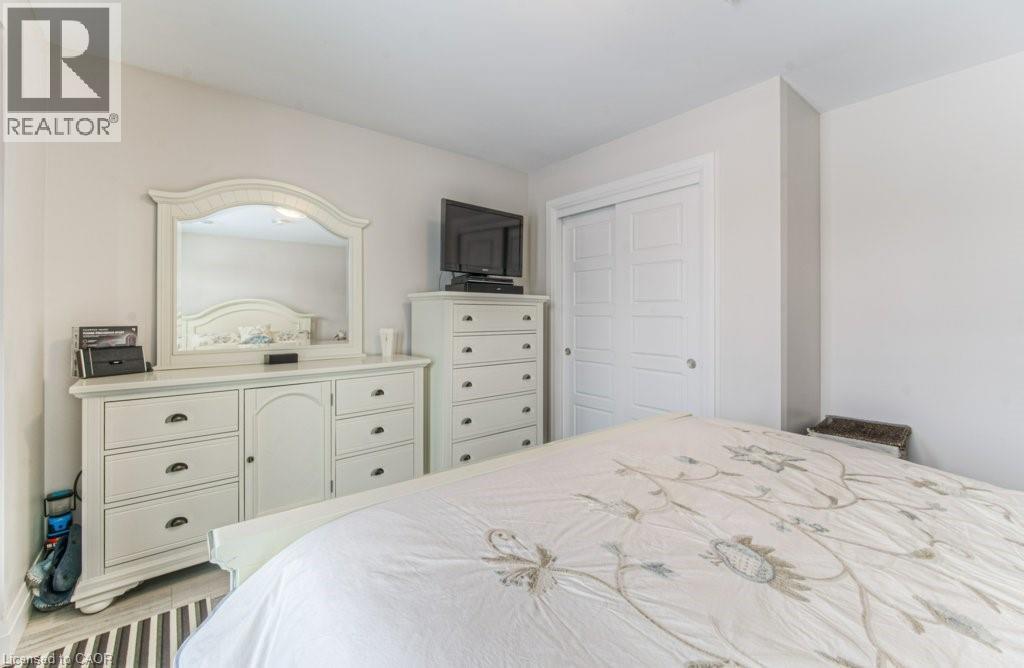 Bedroom featuring light-toned walls and wood-finish flooring - 5 Wake Robin Drive Unit# 107, Kitchener, ON