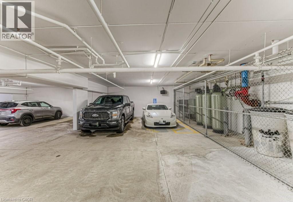 Underground parking area featuring concrete flooring and a white painted ceiling with exposed pipework - 5 Wake Robin Drive Unit# 107, Kitchener, ON