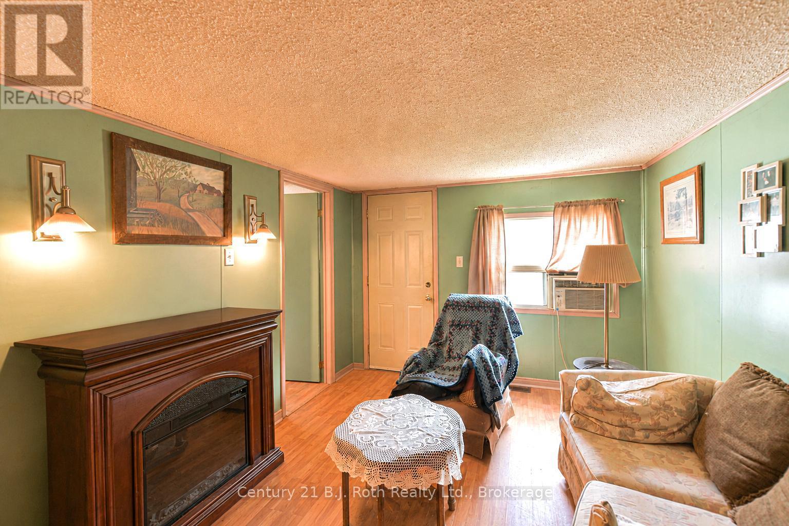 Living Room with electric fireplace (AI enhanced) - 3427 Coronation Avenue, Severn (West Shore), ON