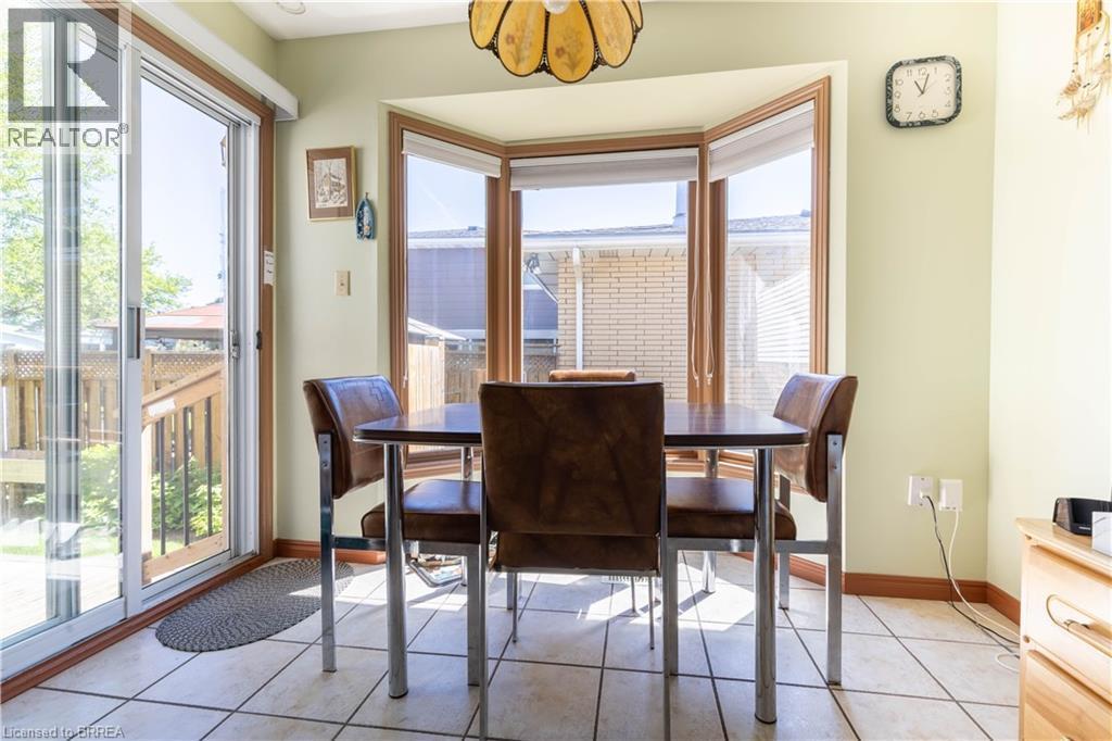 Tiled flooring extending to a bay window and sliding glass door - 12 Spartan Drive, Brantford, ON - Indoor Photo Showing Dining Room