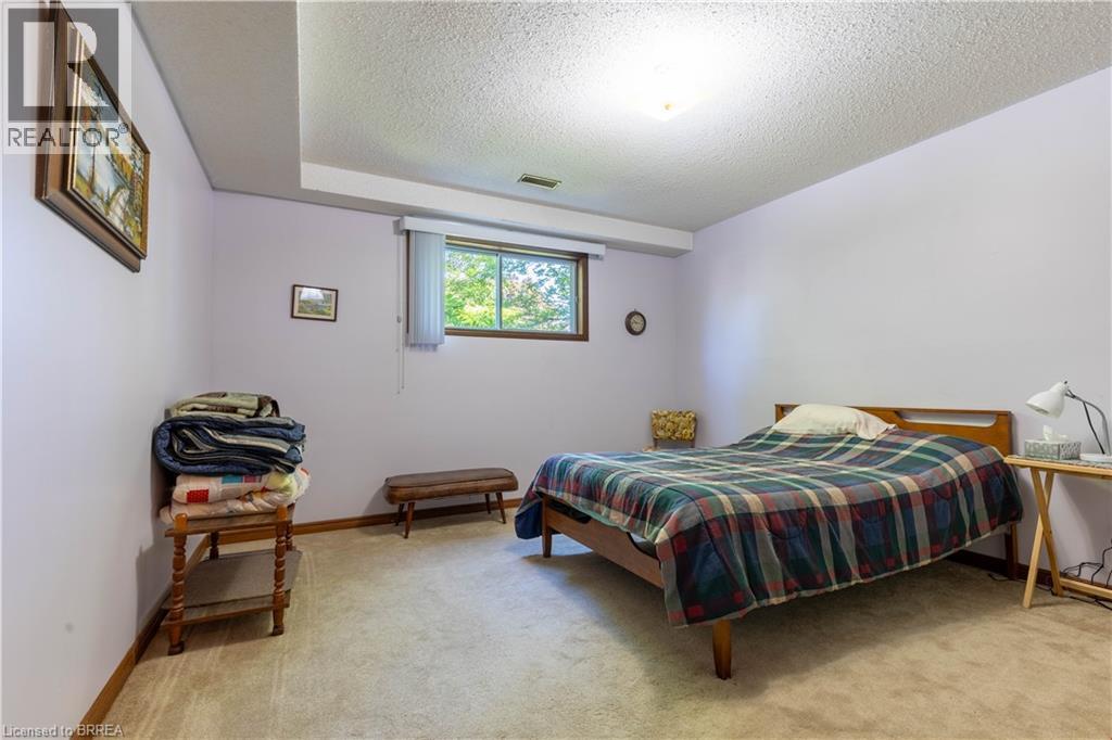 Carpeted room featuring a window with natural light, light-colored walls, and wood-finish trim - 12 Spartan Drive, Brantford, ON - Indoor Photo Showing Bedroom