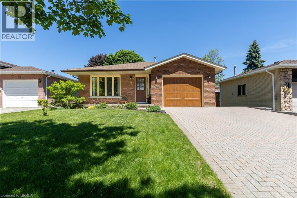 Brick exterior with a peaked roofline, featuring a single-car garage with a wood-finish door - 12 Spartan Drive, Brantford, ON - Outdoor