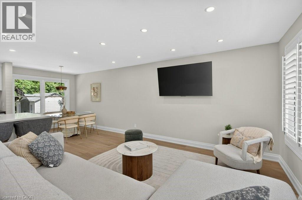 Open-concept living area with light wood-finish flooring, recessed lighting, and crisp white trim - 603 Cornick Drive, Burlington, ON