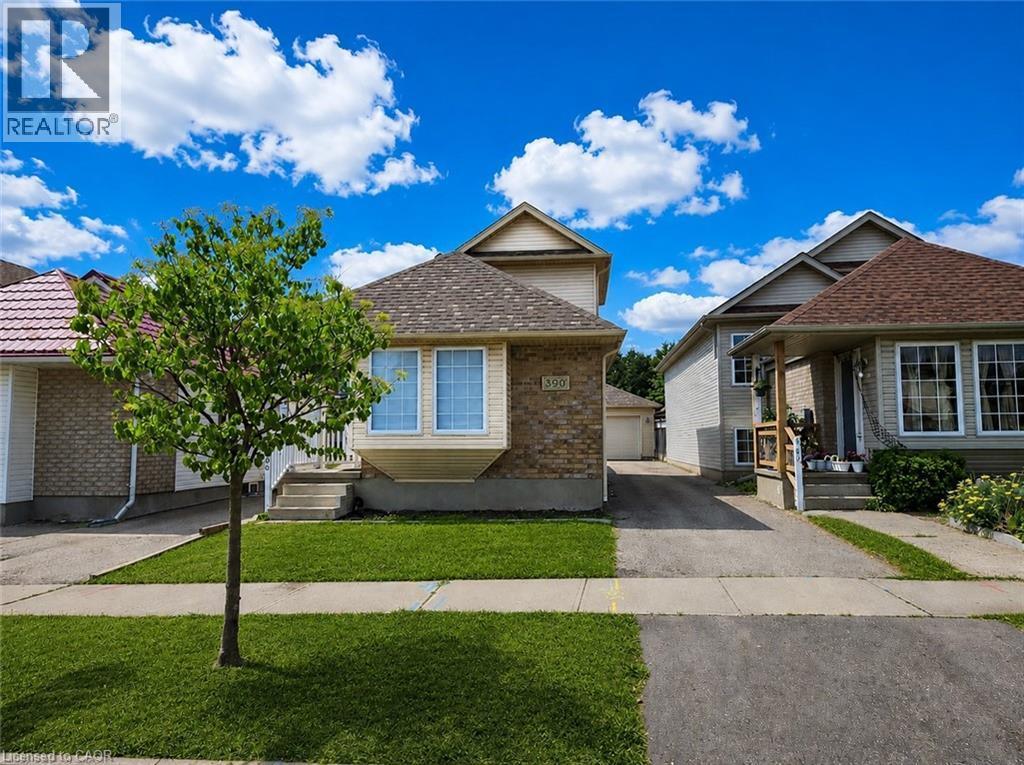 Traditional-style residence featuring a brick and siding facade, a bay window, a shingled roof, a concrete walkway, and a manicured front lawn - 390 Wake Robin Crescent, Kitchener, ON - Outdoor With Facade