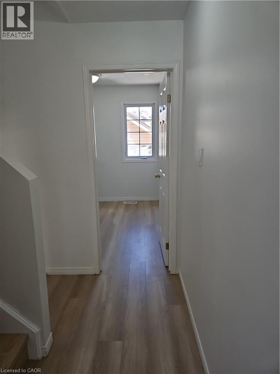 Hallway featuring wood-finish flooring, white painted walls, and a recessed ceiling light - 390 Wake Robin Crescent, Kitchener, ON - Indoor Photo Showing Other Room