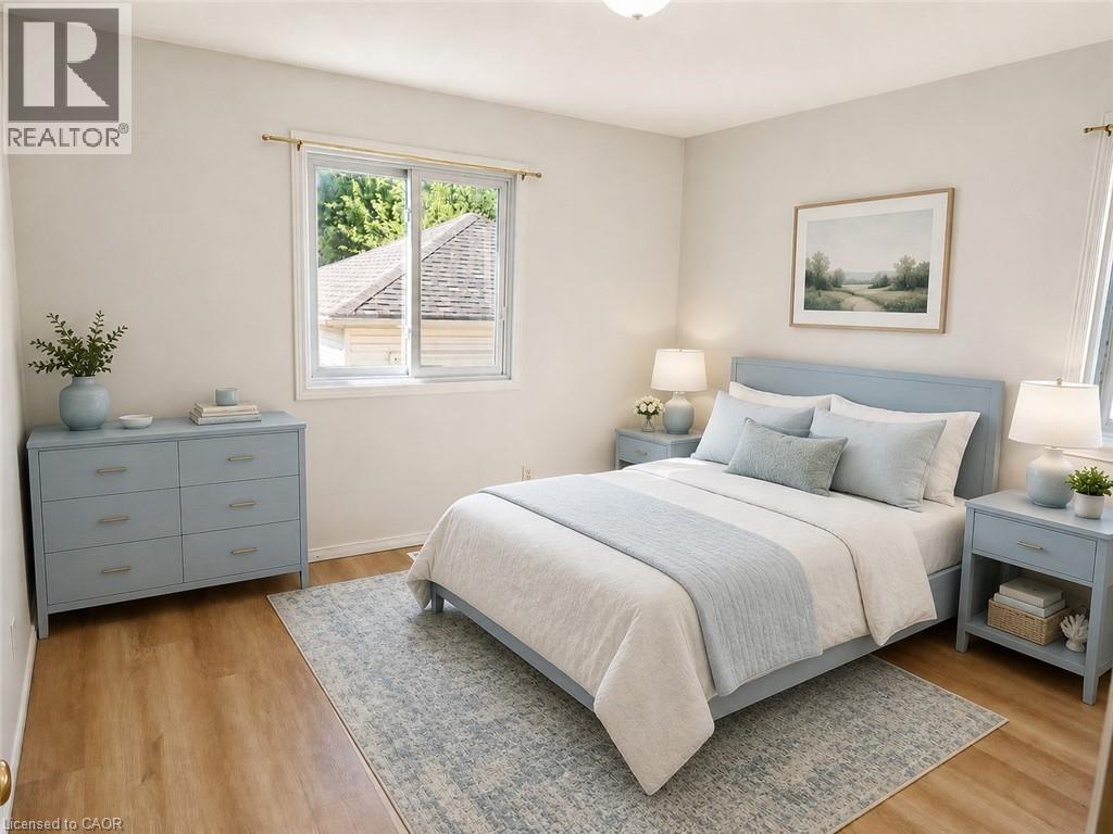 Bedroom featuring a window with a brass curtain rod, light-toned wall paint, wood-finish flooring, and a flush-mount ceiling light fixture - 390 Wake Robin Crescent, Kitchener, ON - Indoor Photo Showing Bedroom