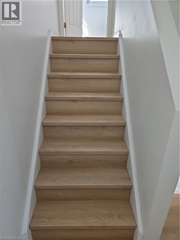 Staircase featuring wood-finish treads and risers with white painted stringers - 390 Wake Robin Crescent, Kitchener, ON - Indoor Photo Showing Other Room
