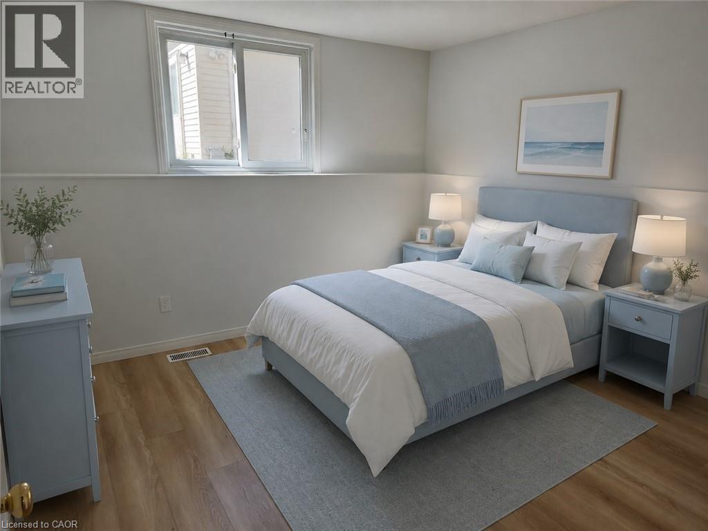 Bedroom featuring light wood-finish flooring, a contemporary white and light gray wall color scheme, and an egress window - 390 Wake Robin Crescent, Kitchener, ON - Indoor Photo Showing Bedroom