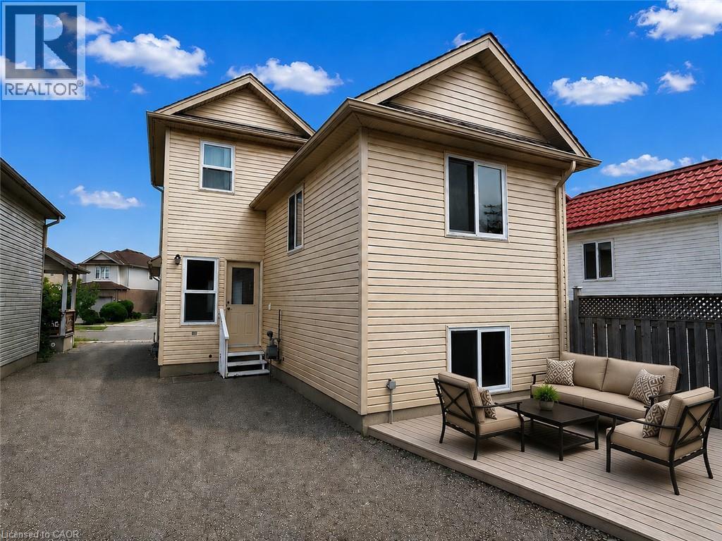 Rear exterior featuring light-colored siding and multiple windows - 390 Wake Robin Crescent, Kitchener, ON - Outdoor With Exterior