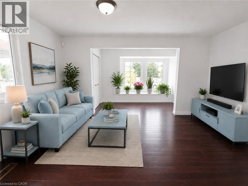 Spacious living area featuring rich wood-finish flooring, crisp white walls, and a recessed ceiling light - 390 Wake Robin Crescent, Kitchener, ON - Indoor Photo Showing Living Room