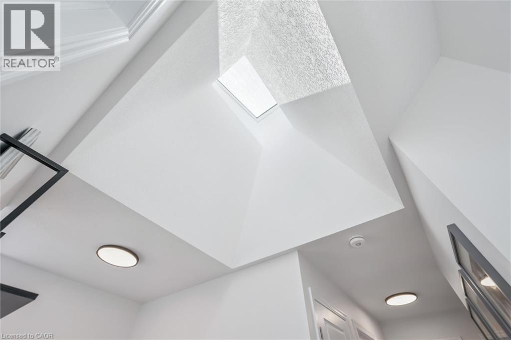 Vaulted ceiling with an integrated skylight, recessed lighting, crown molding, and contemporary wall decor - 30 Waterbow Trail, Kitchener, ON - Indoor Photo Showing Other Room