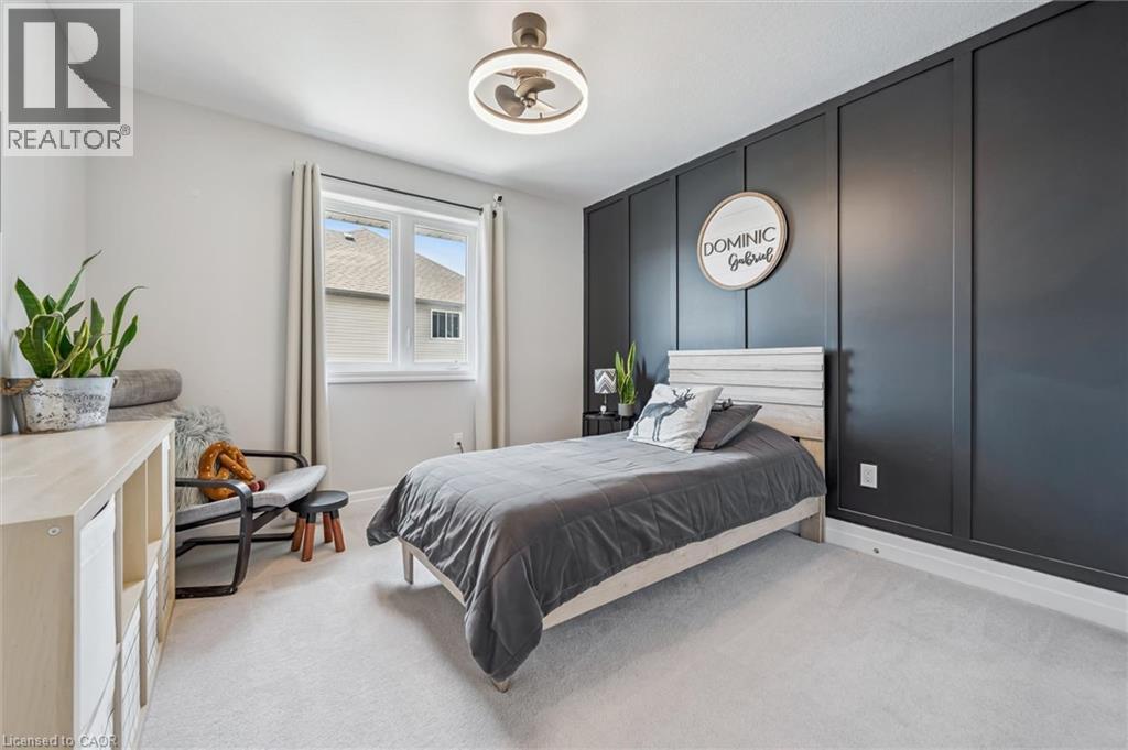 Light gray carpeting complements a dark paneled accent wall - 30 Waterbow Trail, Kitchener, ON - Indoor Photo Showing Bedroom