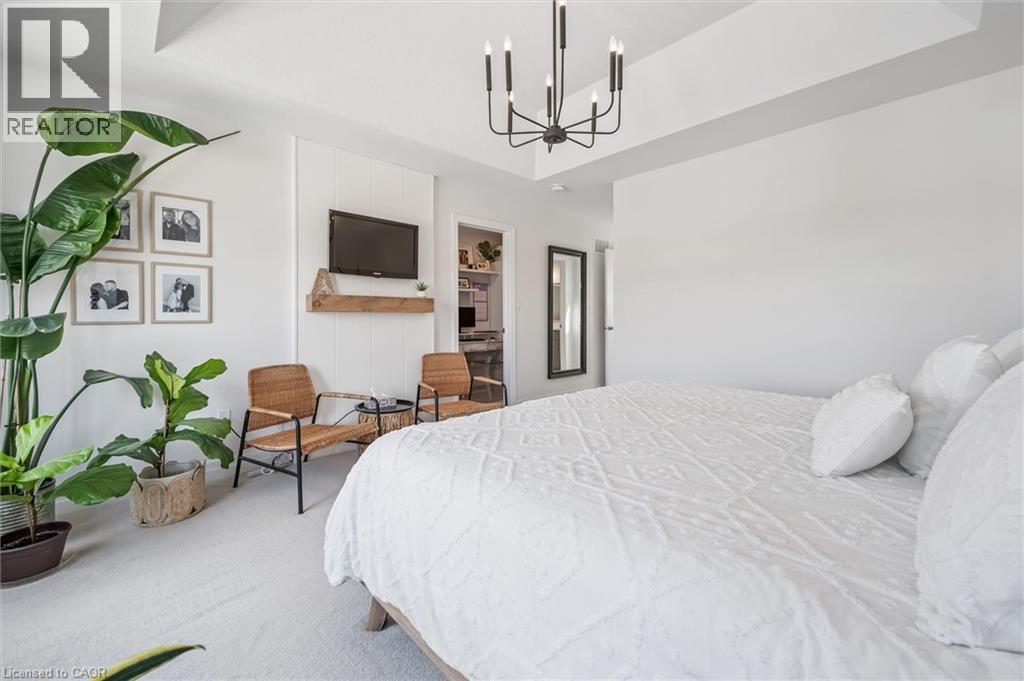 Spacious bedroom featuring recessed lighting, a contemporary black chandelier, and light-colored carpeting - 30 Waterbow Trail, Kitchener, ON - Indoor Photo Showing Bedroom