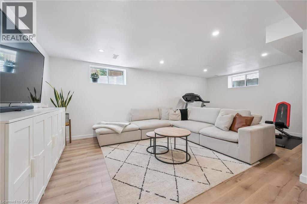 Spacious recreation room featuring recessed lighting and wood-finish flooring - 30 Waterbow Trail, Kitchener, ON - Indoor