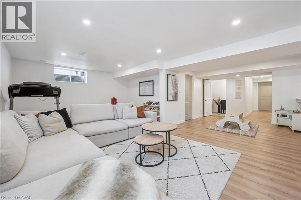Spacious lower-level living area featuring recessed lighting, light wood-finish flooring, and white walls - 30 Waterbow Trail, Kitchener, ON - Indoor Photo Showing Basement