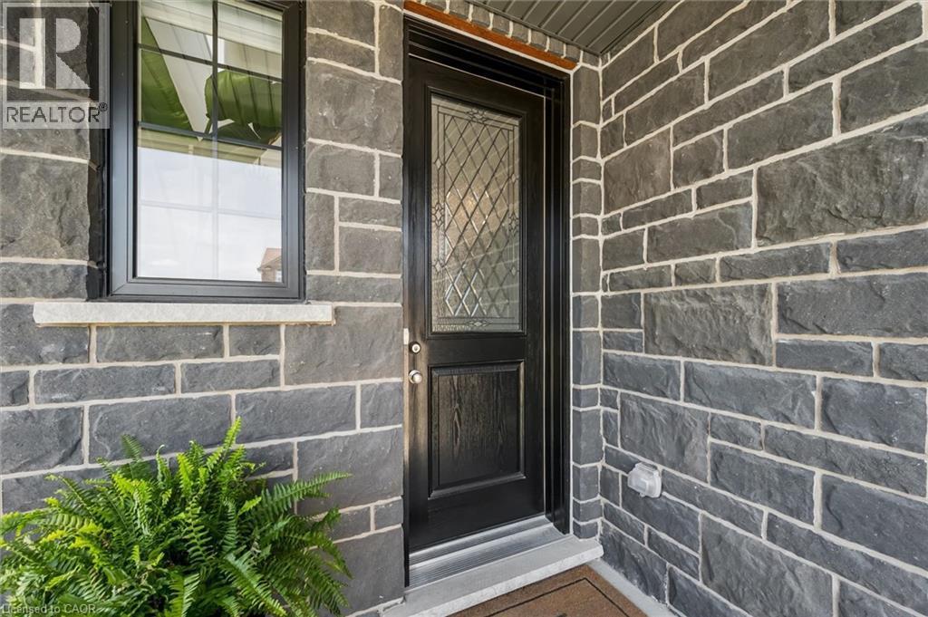 Entryway featuring a dark wood-finish door with leaded glass, framed by stone veneer siding - 30 Waterbow Trail, Kitchener, ON - Photo Showing Other Room