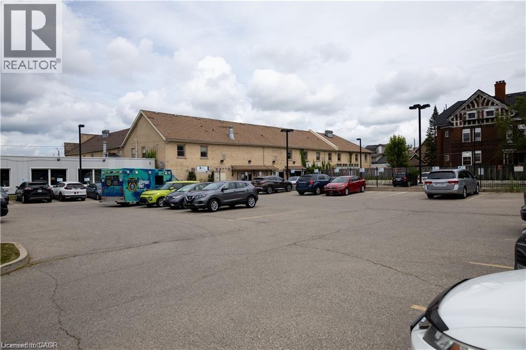 Expansive paved parking area with multiple parking spaces and perimeter lighting fixtures - 365 Colborne Street, Brantford, ON