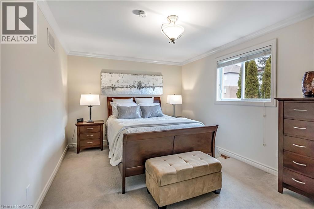 Carpeted bedroom featuring a window, ceiling light fixture, crown molding, baseboards, and a wall vent - 640 Acadia Drive, Hamilton, ON