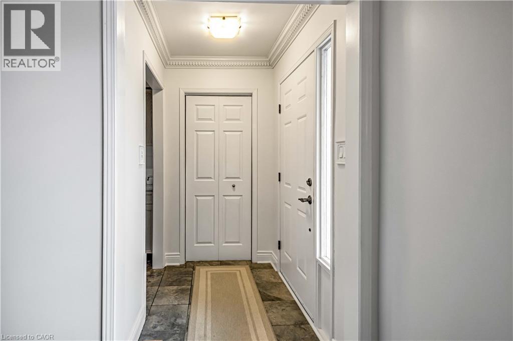 Entryway featuring slate-style flooring, white walls, and decorative crown molding - 640 Acadia Drive, Hamilton, ON