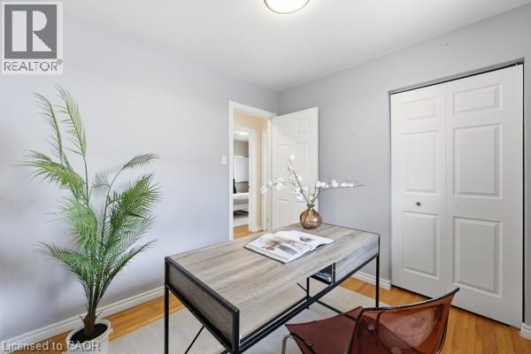 Light gray painted walls with white trim, wood-finish flooring, and a flush mount ceiling light fixture - 957 Stone Church Road E, Hamilton, ON - Indoor