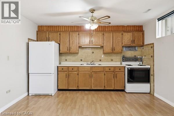 Kitchenette area featuring wood-finish flooring, wood cabinetry, a double basin sink, a full-size refrigerator, and an electric range - 957 Stone Church Road E, Hamilton, ON - Indoor Photo Showing Kitchen With Double Sink