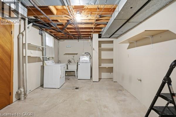 Laundry area featuring concrete flooring, built-in shelving, a utility sink, a washer, and a dryer - 957 Stone Church Road E, Hamilton, ON - Indoor Photo Showing Laundry Room