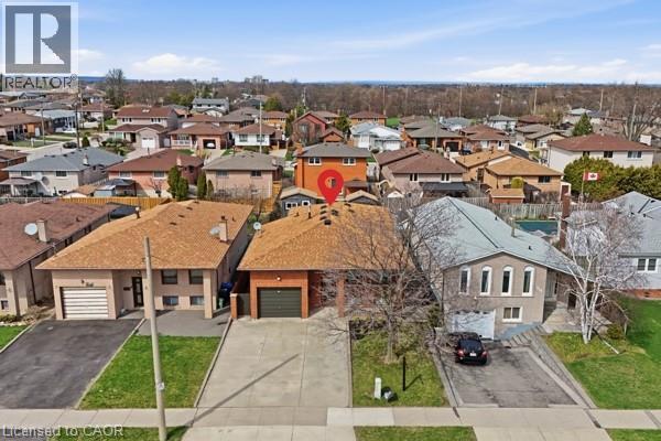 Brick exterior residence featuring an attached single-car garage and a paved driveway - 957 Stone Church Road E, Hamilton, ON - Outdoor