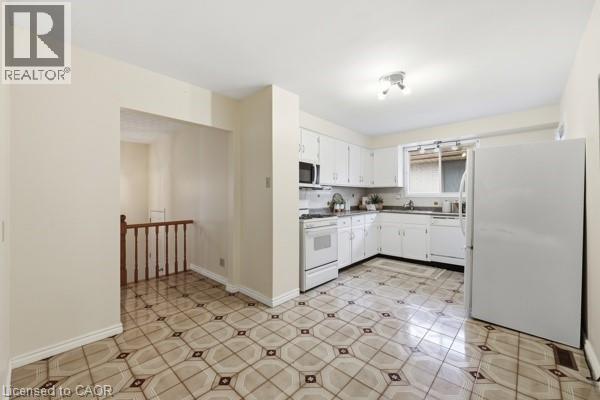 Kitchen featuring white cabinetry, a built-in microwave, an electric range, and a double-basin sink - 957 Stone Church Road E, Hamilton, ON - Indoor Photo Showing Kitchen
