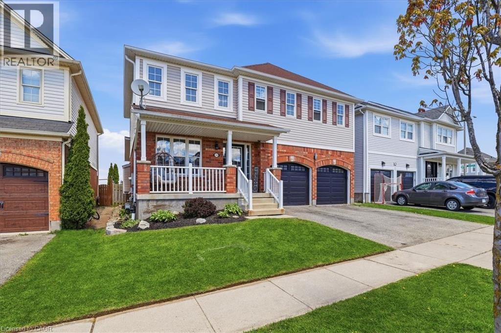 Two-story residence featuring light-colored siding, red brick accents, and a covered front porch with white railings - 136 Carpenter Road, Cambridge, ON - Outdoor With Deck Patio Veranda With Facade