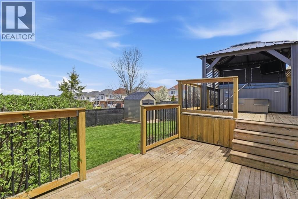 Expansive backyard featuring a multi-level wood deck with black metal balusters, a built-in gazebo, and a hot tub - 136 Carpenter Road, Cambridge, ON - Outdoor With Deck Patio Veranda With Exterior