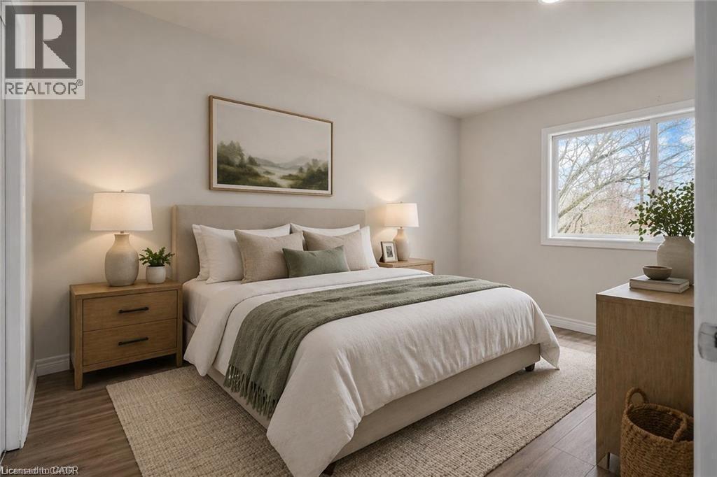 Bedroom featuring wood-finish flooring, light neutral wall paint, and a large window - 22 Blackhorne Crescent, Kitchener, ON - Indoor Photo Showing Bedroom