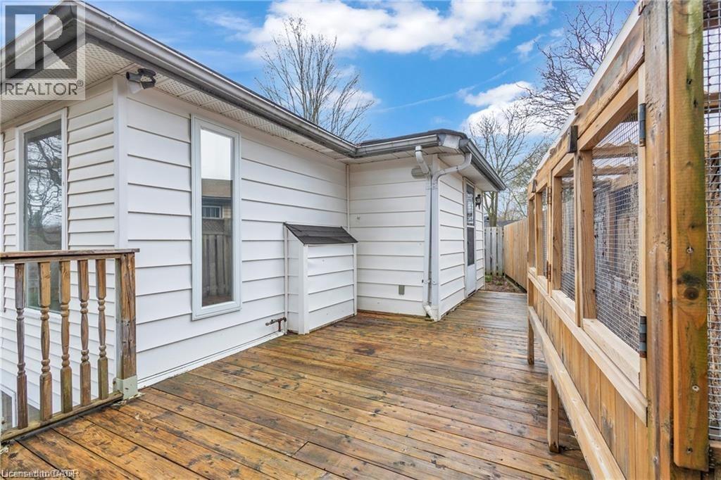 Expansive wood deck with a built-in wooden railing, white horizontal siding, and a wooden fence boundary - 22 Blackhorne Crescent, Kitchener, ON - Outdoor With Exterior
