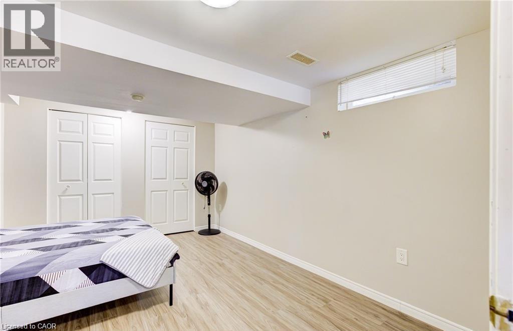Room featuring wood-finish flooring, light-toned walls, and a ceiling-mounted light fixture - 22 Blackhorne Crescent, Kitchener, ON - Indoor Photo Showing Bedroom