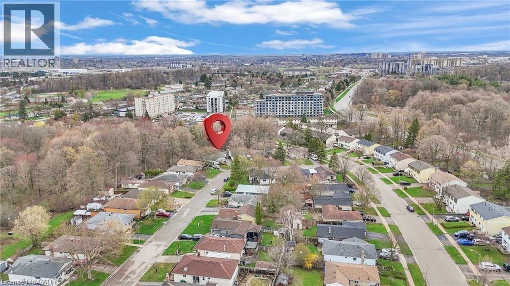 Aerial perspective highlighting a residential street lined with single-story homes, surrounded by mature trees - 22 Blackhorne Crescent, Kitchener, ON - Outdoor With View
