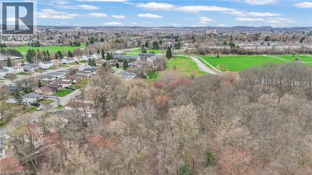 Expansive aerial perspective showcasing a residential development bordered by natural wooded areas and green spaces - 22 Blackhorne Crescent, Kitchener, ON - Outdoor With View