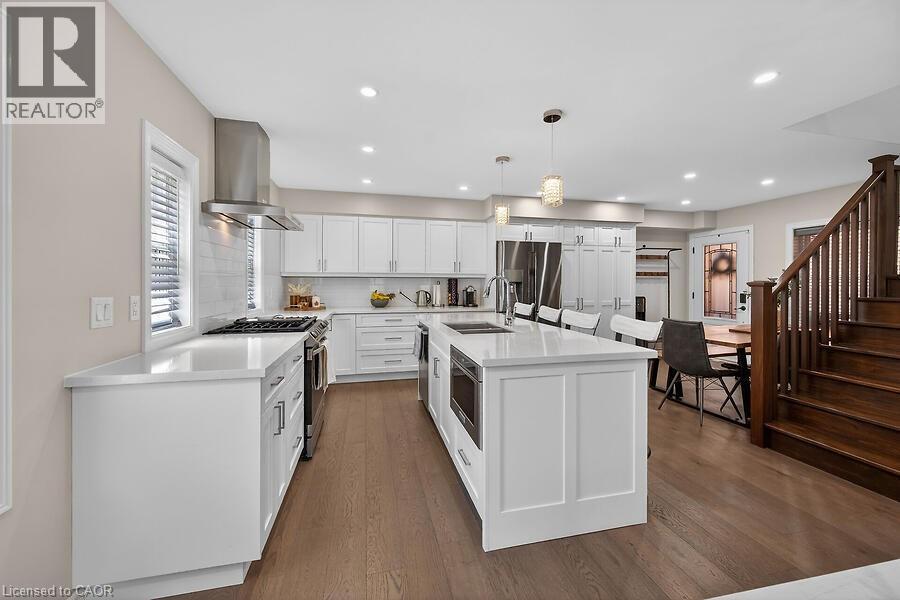 Modern kitchen featuring white cabinetry and light-toned countertops - 109 Ray Street N, Hamilton, ON - Indoor Photo Showing Kitchen With Double Sink