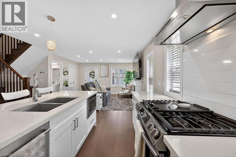 Modern kitchen featuring white cabinetry, light countertops, and a dual basin undermount sink - 109 Ray Street N, Hamilton, ON - Indoor Photo Showing Kitchen With Double Sink With Upgraded Kitchen