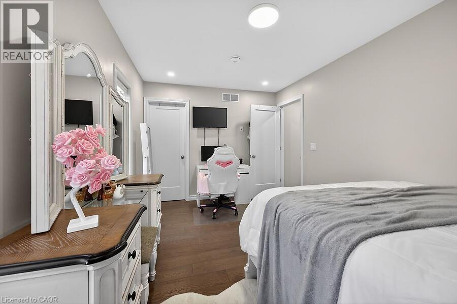 Recessed lighting illuminates wood-finish flooring - 109 Ray Street N, Hamilton, ON - Indoor Photo Showing Bedroom