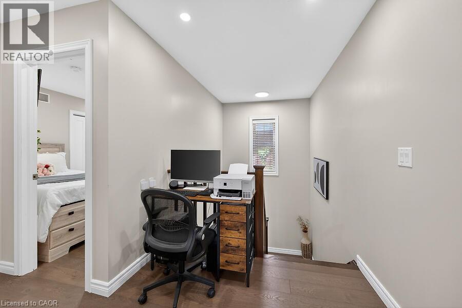 Versatile bonus area featuring rich wood-finish flooring, recessed lighting, a single window with blinds, and white baseboards - 109 Ray Street N, Hamilton, ON - Indoor Photo Showing Office