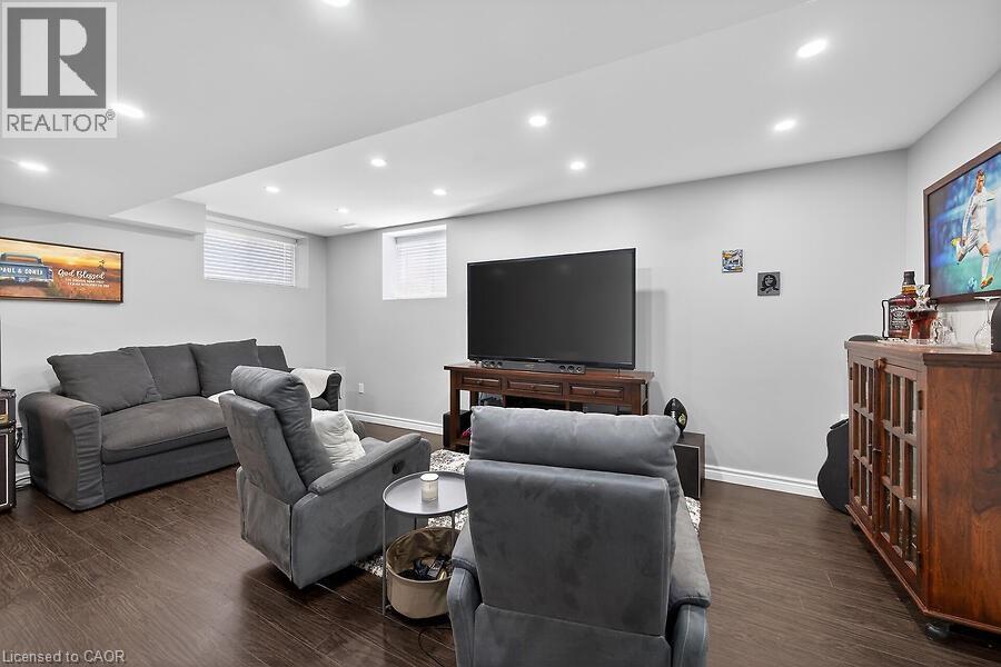 Recessed lighting illuminates this open room with wood-finish flooring - 109 Ray Street N, Hamilton, ON - Indoor Photo Showing Basement