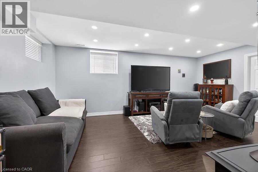 Recreation room featuring recessed lighting, light-colored walls, dark wood-finish flooring, and white trim - 109 Ray Street N, Hamilton, ON - Indoor Photo Showing Basement