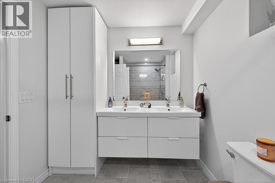 Modern bathroom featuring a double vanity with two rectangular vessel sinks, under-sink storage drawers, and a large wall-mounted mirror - 109 Ray Street N, Hamilton, ON - Indoor Photo Showing Bathroom