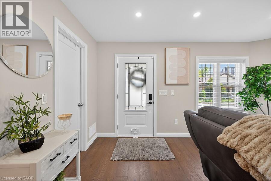 Entryway featuring a white door with decorative glass, dark wood-finish flooring, recessed lighting, and a double-hung window with blinds - 109 Ray Street N, Hamilton, ON - Indoor Photo Showing Other Room