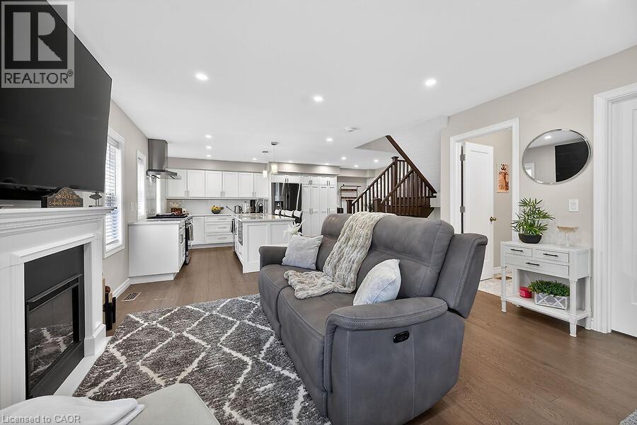 Spacious living area featuring a fireplace with a white mantel, recessed lighting, and wood-finish flooring - 109 Ray Street N, Hamilton, ON - Indoor Photo Showing Living Room With Fireplace
