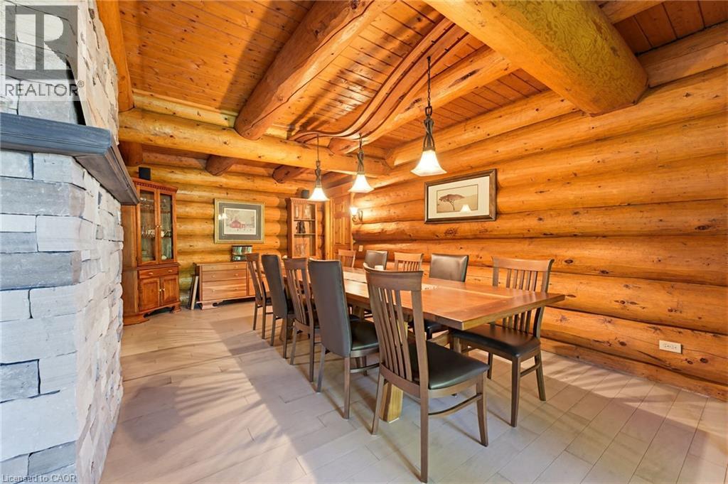 Dining area featuring natural wood-finish log walls and ceiling, exposed timber beams, and light-toned wood-finish flooring - 169 James Street, Atwood, ON - Indoor Photo Showing Dining Room