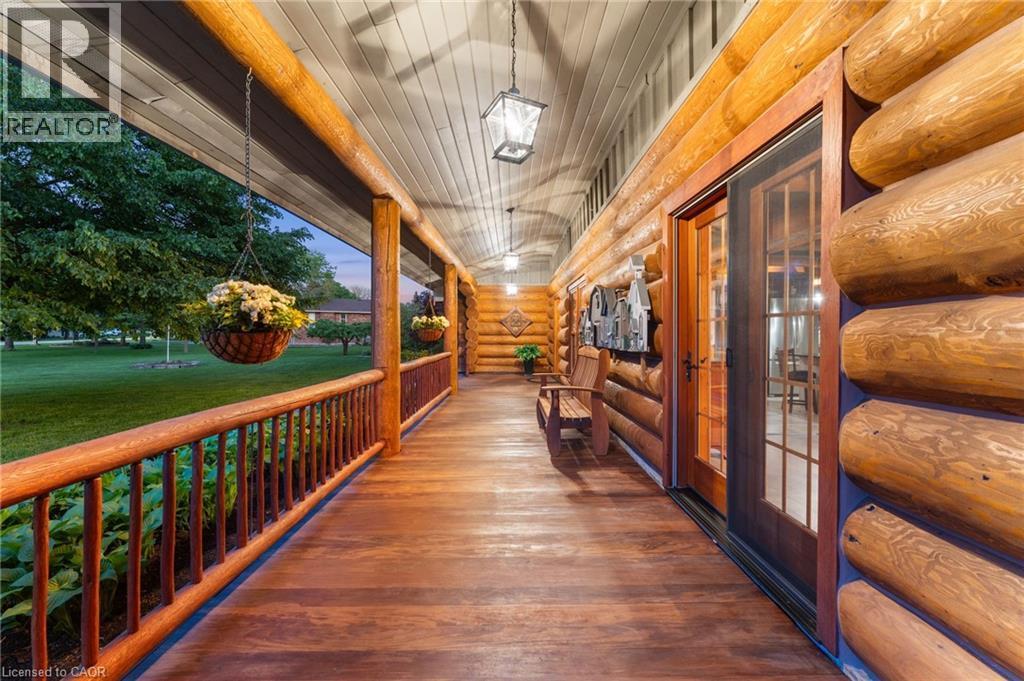 Expansive covered porch featuring a rich wood-finish floor and log construction - 169 James Street, Atwood, ON - Indoor Photo Showing Other Room