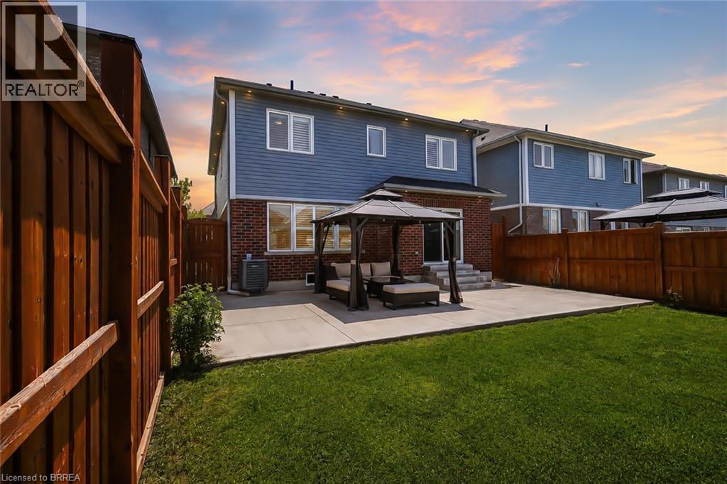 Spacious backyard featuring a large concrete patio, a lush lawn, and a privacy fence - 26 Pollard Street, Brantford, ON - Outdoor