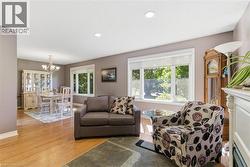 Open-concept living and dining area featuring hardwood flooring, recessed lighting, and ample natural light from multiple windows -