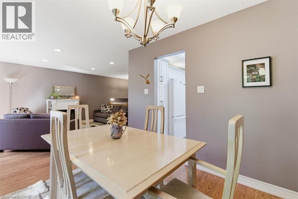 Dining area featuring a contemporary chandelier, wood-finish flooring, and neutral wall tones - 26 Sideroad 18, Fergus, ON - Indoor Photo Showing Dining Room