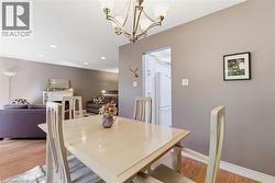 Dining area featuring a contemporary chandelier, wood-finish flooring, and neutral wall tones -